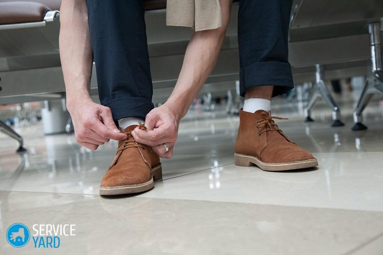 Homme à l'aéroport laçant ses chaussures en daim